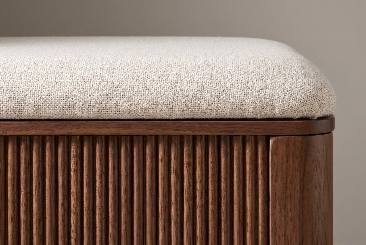 Close-up of the ivory linen-look seat pad, the thin walnut rim and the half-round reeds meeting the plain rounded corner