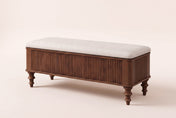 Salerno reeded storage bench in walnut with an ivory linen-look seat, three-quarter view on a warm cream studio backdrop