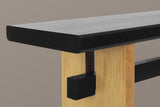 Close-up of a light wood slab leg: the slot under the black top