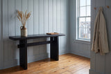Sanremo console table against blue-grey panelling in an entry with a harbour window, dried grasses in a stoneware jug