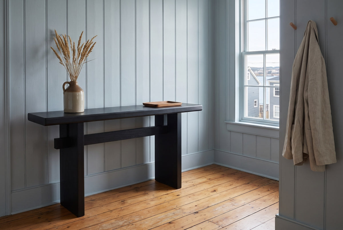 Sanremo console table against blue-grey panelling in an entry with a harbour window, dried grasses in a stoneware jug