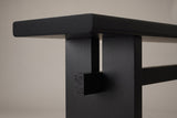 Close-up of a black slab leg: the slot under the top, the recessed post and the square stretcher end showing its end grain