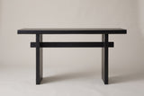 Sanremo console table in black, straight front view: a thick top, two slab legs and one stretcher through both