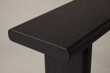 Close-up of the 2.4-inch black top: softly rounded edge and corner, fine straight grain under a matte stain