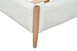 Close-up of a Sarnano foot corner: the round Sand oak post set into the upholstered rail and its tapered leg