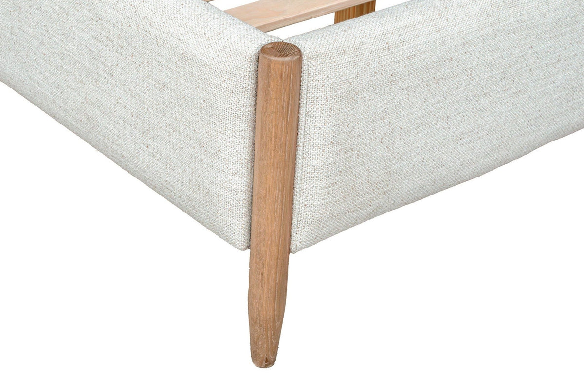 Close-up of a Sarnano foot corner: the round Sand oak post set into the upholstered rail and its tapered leg