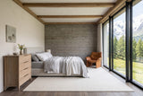 Sarnano chest in Sand in a Saas-Fee chalet bedroom, with lime plaster, a grey-washed larch wall