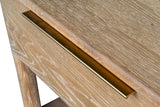 Close-up of the Sarnano drawer front in limed Sand oak with its slim brass edge pull, a round leg and the shelf below