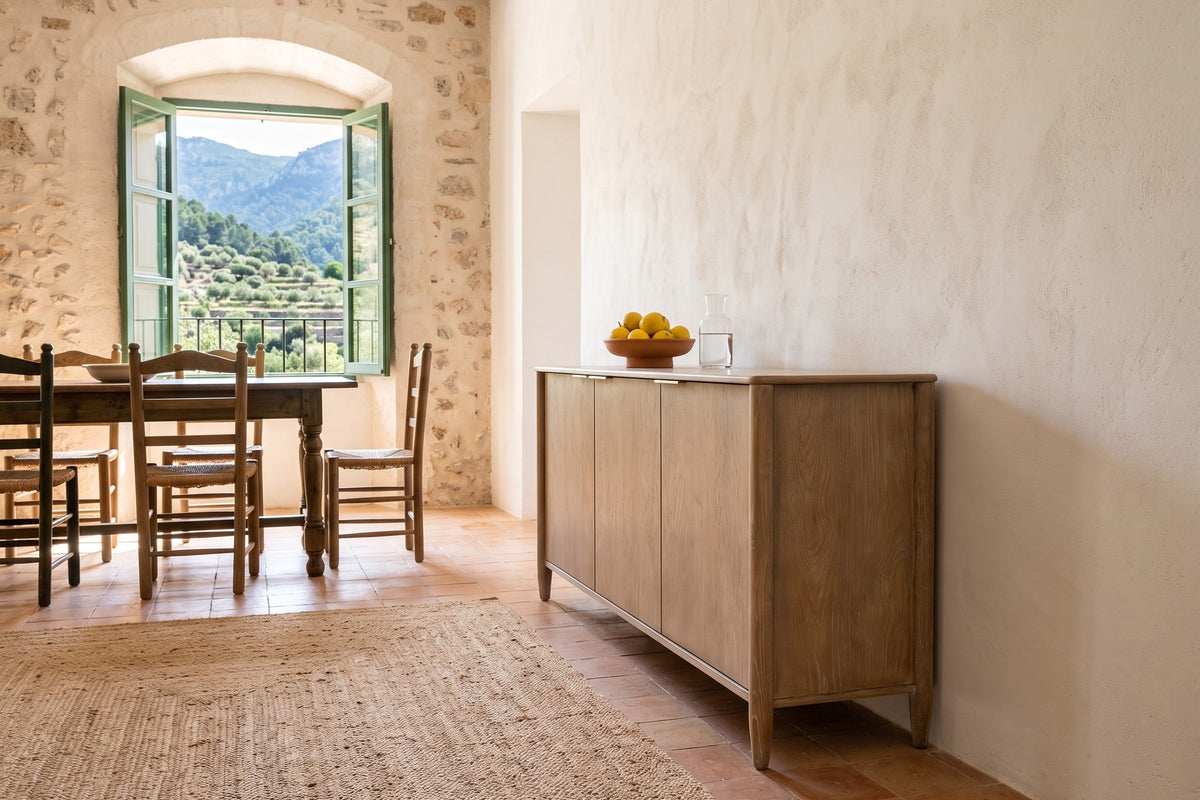 Sarnano sideboard in Sand seen from the end along a lime plaster wall in a stone finca in Fornalutx, with a terracotta floor