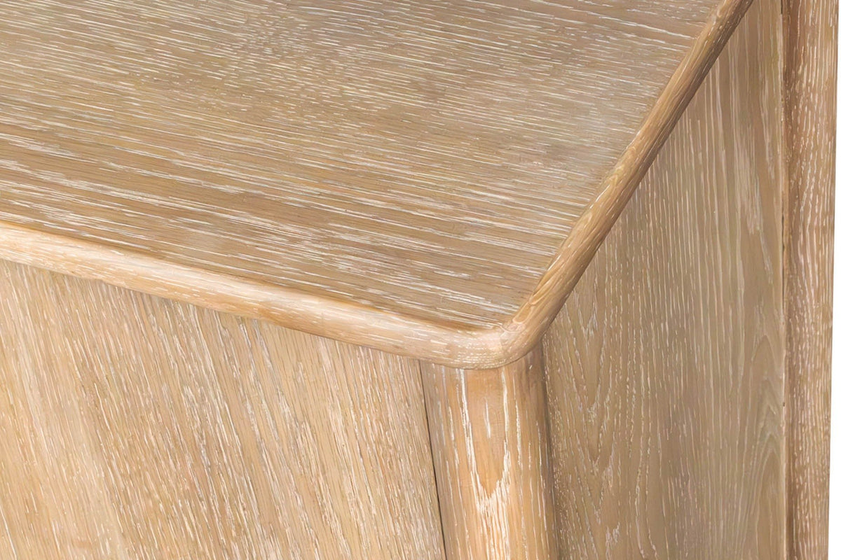 Close-up of a corner of the Sarnano sideboard in Sand: the softly rounded top edge above a round corner post and the oak grai