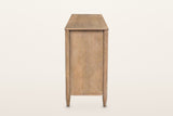 Sarnano sideboard in Sand, end view on a warm white studio backdrop: a plain oak end panel between two round posts on tapered