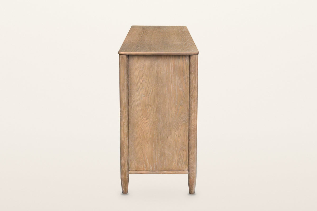 Sarnano sideboard in Sand, end view on a warm white studio backdrop: a plain oak end panel between two round posts on tapered