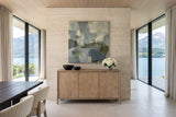 Sarnano sideboard in Sand, front view, against a double-height travertine wall with abstract art in a Vitznau lakeside villa