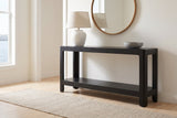 Sarnico console table in black in a white front hall above the harbour, a lamp and a stone bowl on top, a round mirror above