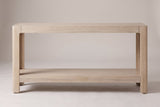 Sarnico console table in natural, straight front view: four rounded legs, a deep top apron and a thick lower shelf