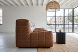 Sassocorvaro sofa in Antique Sienna seen from the end in an Antwerp canal loft, with whitewashed brick