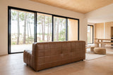 Sassocorvaro sofa in Antique Sienna seen from behind in a Hossegor pine house, its padded back to the camera