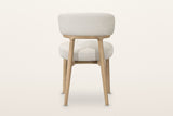 The back of the Savoca dining chair in Porcelain Chenille on a warm white studio backdrop