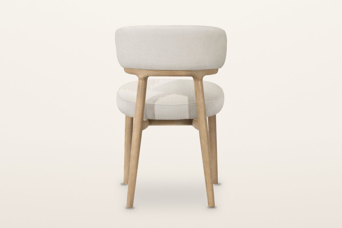 The back of the Savoca dining chair in Porcelain Chenille on a warm white studio backdrop