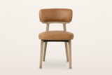 Savoca dining chair in Tawny leather, front view on a warm white studio backdrop