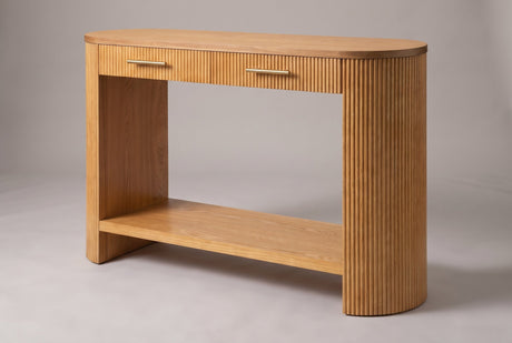 Savona reeded 2-drawer console table in natural honey-toned wood, three-quarter view on a warm grey studio backdrop