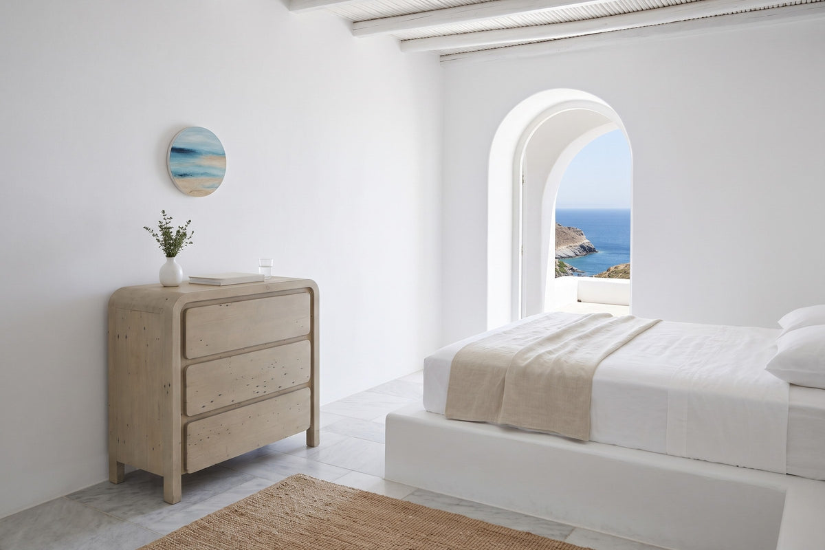 Scheggino chest in a bedroom of a Patmos cliff house, with white lime plaster, a cedar-pole ceiling