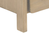 Close-up of a Scheggino square leg in pale reclaimed pine, under the planked side and the rounded corner of the lower drawer