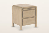 Scheggino nightstand in pale reclaimed pine, three-quarter view on a warm white studio backdrop: a waterfall top with rounded