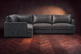 Serena corner sectional in Aged Slate on a walnut herringbone floor, seen from the front with the near side on the left.