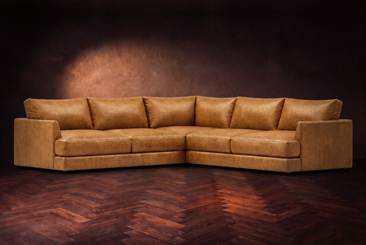 Serena corner sectional in Antiqued Caramel on a walnut herringbone floor, three-quarter view.