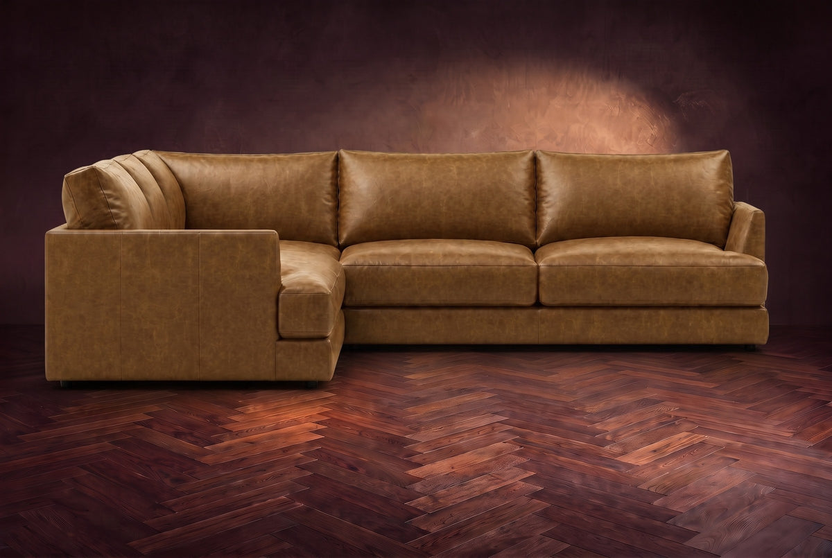 Serena corner sectional in Weathered Saddle on a walnut herringbone floor, seen from the front with the near side on the left.