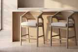 Two Sermoneta counter stools in Natural Ash in front of a pale oak island with a white stone top in a plaster-walled kitchen