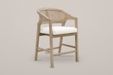 Sermoneta cane-back counter stool in Natural Ash, front three-quarter view on a warm light-grey studio backdrop