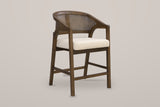 Sermoneta cane-back counter stool in Walnut, front three-quarter view on a warm light-grey studio backdrop