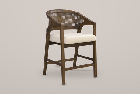 Sermoneta cane-back counter stool in Walnut, front three-quarter view on a warm light-grey studio backdrop