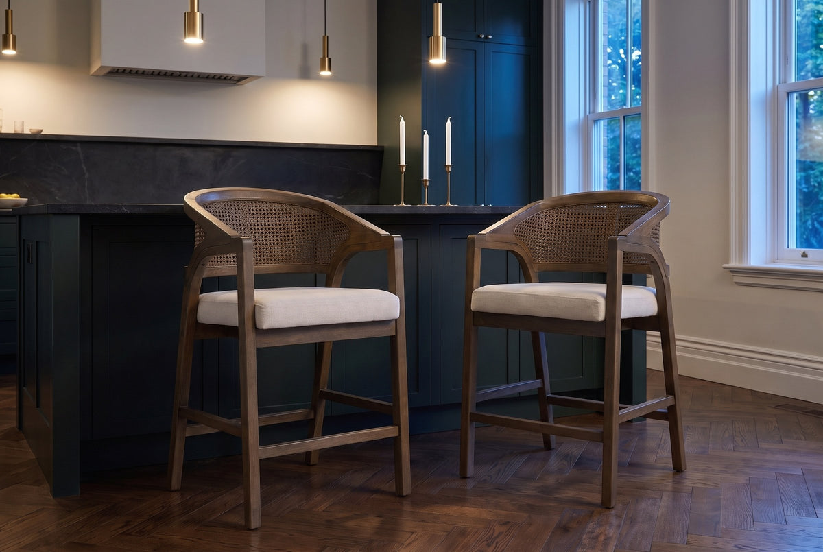 Two Sermoneta counter stools in Walnut pulled out from a stone-topped island in a dark green Toronto kitchen at dusk