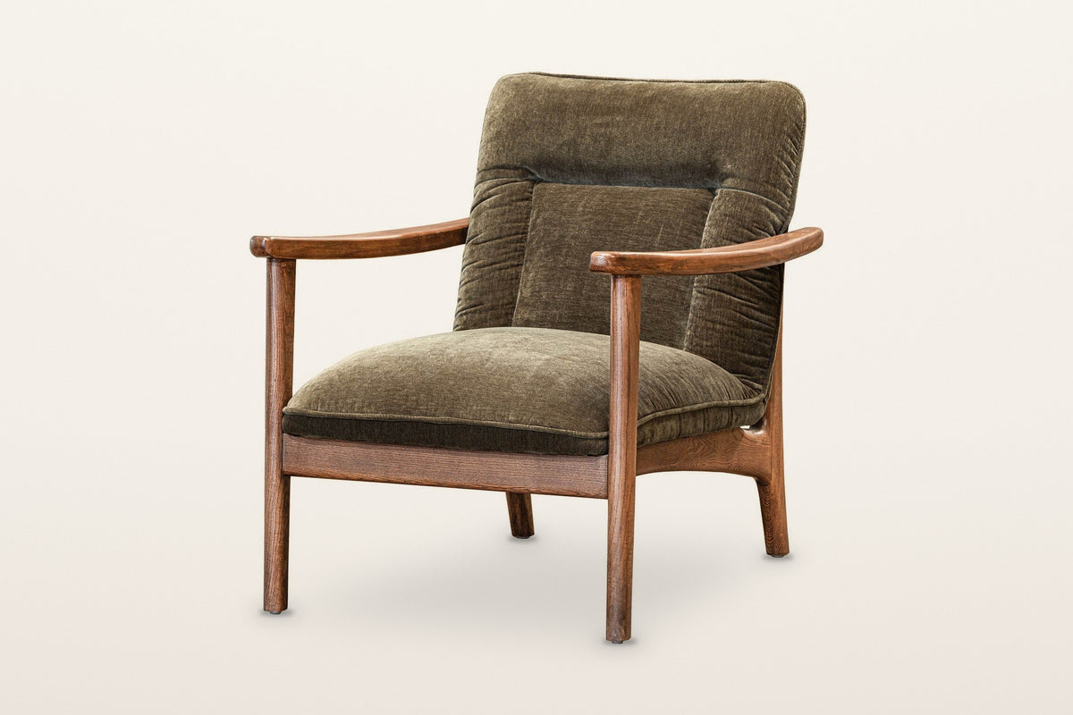 Servigliano accent chair in Green, three-quarter view on a warm white studio backdrop: a brown ash frame with flat wooden arm