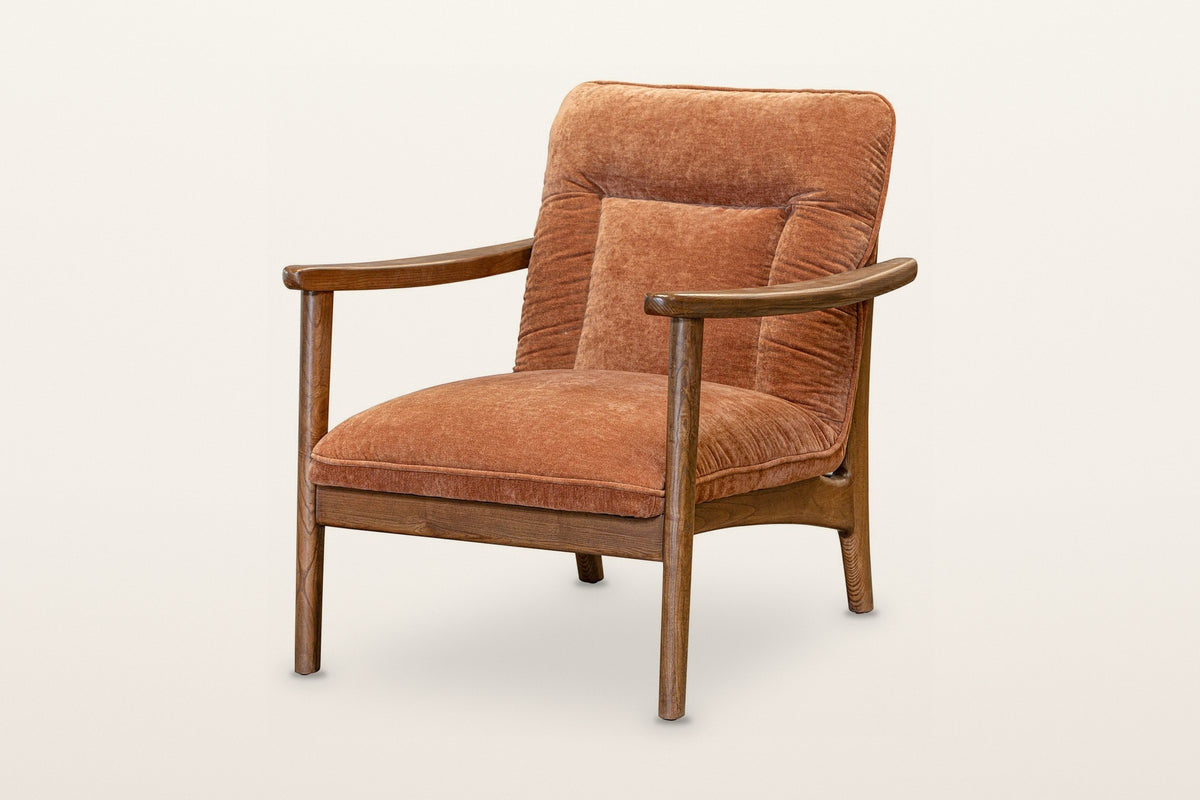 Servigliano accent chair in Rust, three-quarter view on a warm white studio backdrop