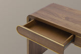 Close-up of the left walnut drawer pulled open on its metal ball-bearing slide, its half-round front with a gold-tone edge