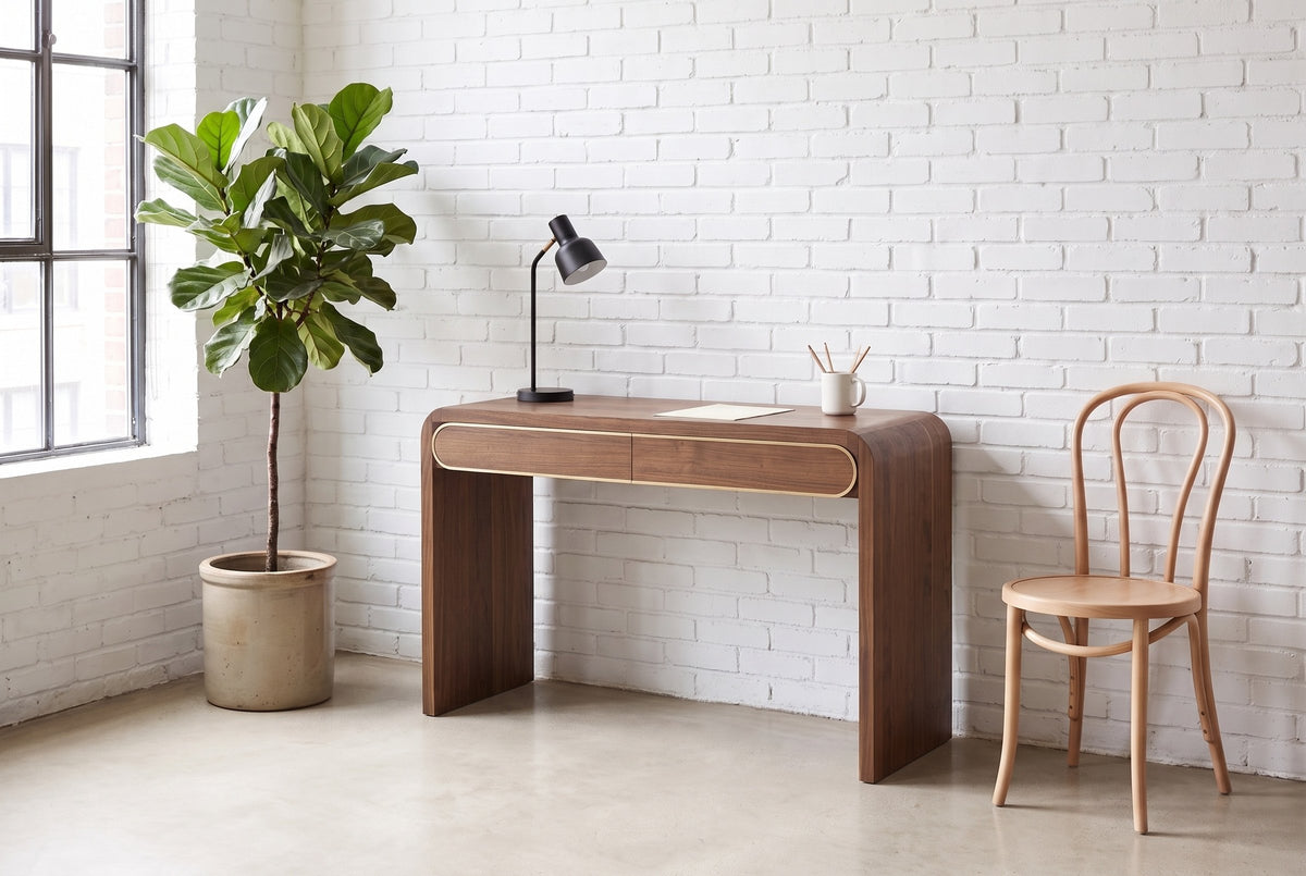 Sestri console table in walnut used as a slim desk against a white brick wall in a Montreal loft, a bentwood chair beside it