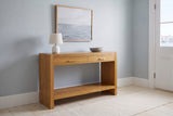 Sibari console table in Natural in a blue-grey Halifax front hall in the morning, a white lamp and a stone bowl on top