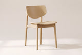 Simone dining chair in natural oak, three-quarter view on a warm off-white studio backdrop