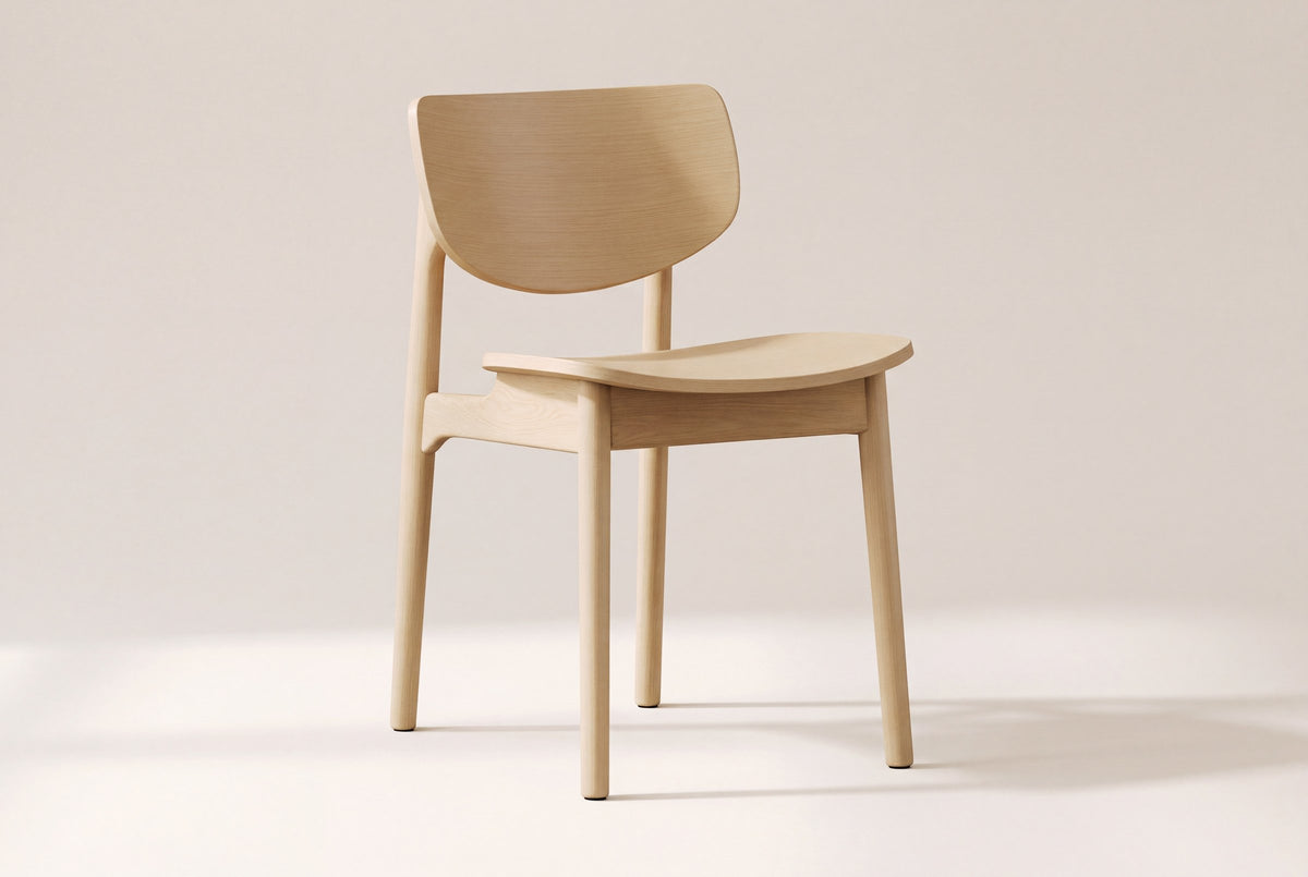 Simone dining chair in natural oak, three-quarter view on a warm off-white studio backdrop