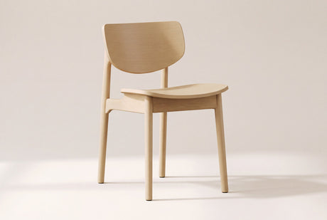 Simone dining chair in natural oak, three-quarter view on a warm off-white studio backdrop