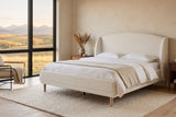 Sirmione boucle wingback bed in a bedroom with a wide window over the foothills at golden hour