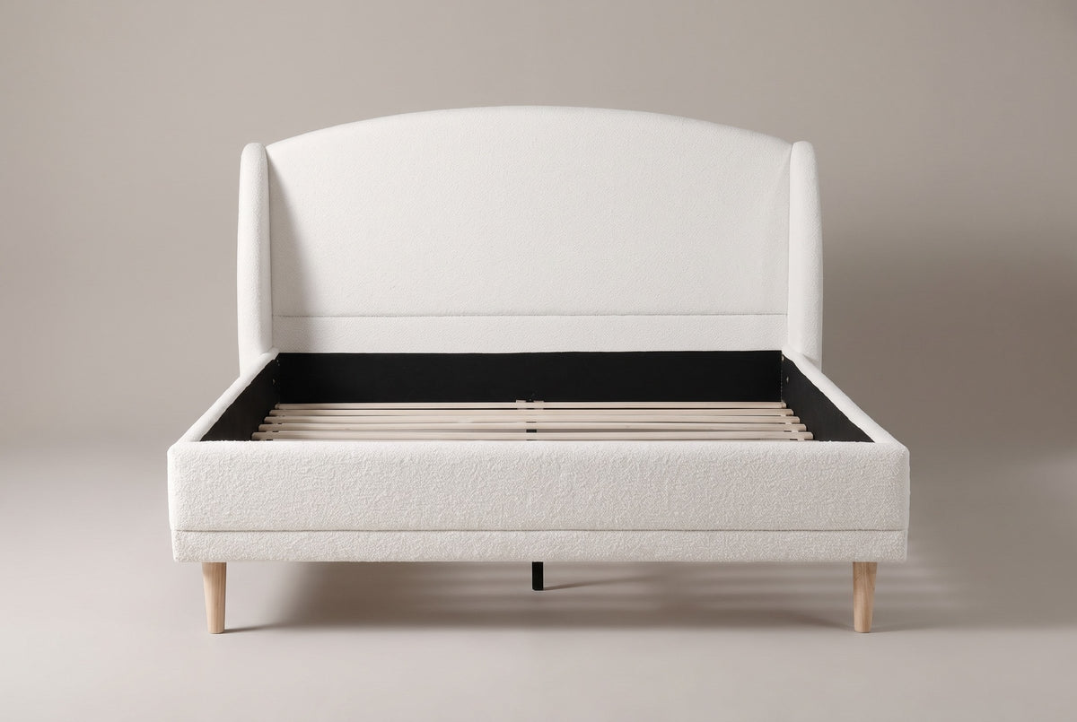 Sirmione wingback bed, straight front view: arched boucle headboard between two rounded wings