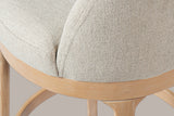 Close-up of the low wrap-around back rising from the seat ring, the curved shoulder of a leg and the footrest ring