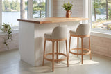 Two Sirolo counter stools at a butcher-block counter by a lake window in a whitewashed Muskoka cottage
