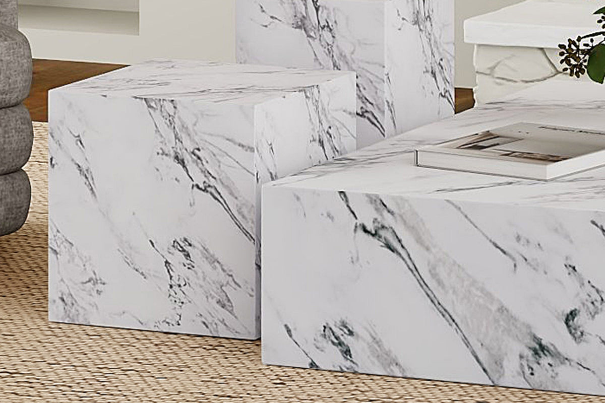 Sloane white marble-look concrete cube grouped with other block tables on a jute rug
