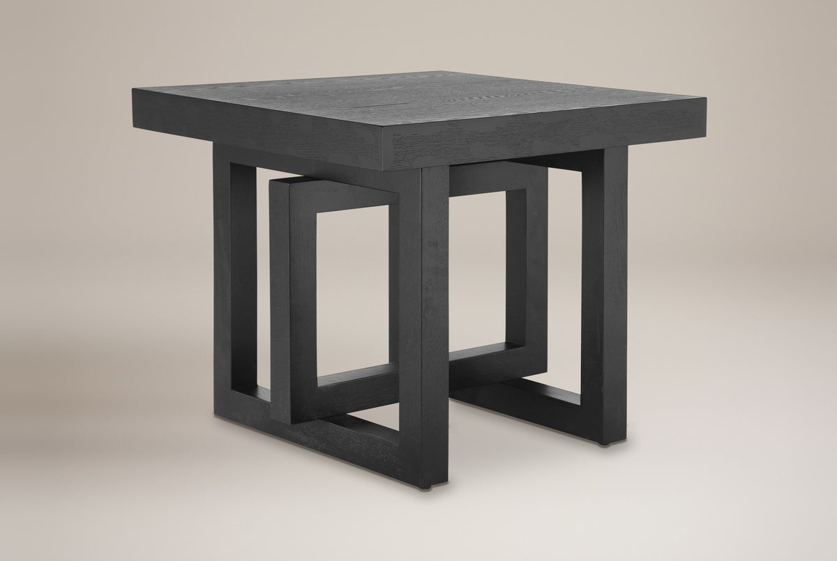Soave square side table in black, three-quarter view on a warm grey studio backdrop